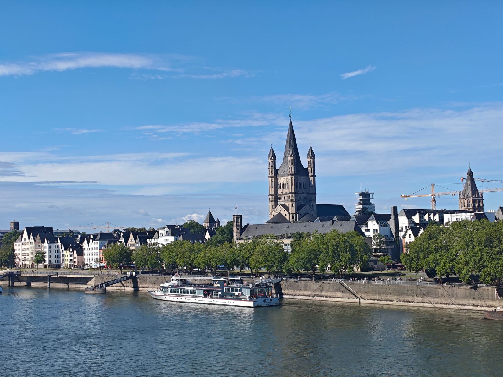 Cologne riverfront and Great St. Martin Church with a ship on the Rhine, one of the busiest rivers for river cruise deals in Europe